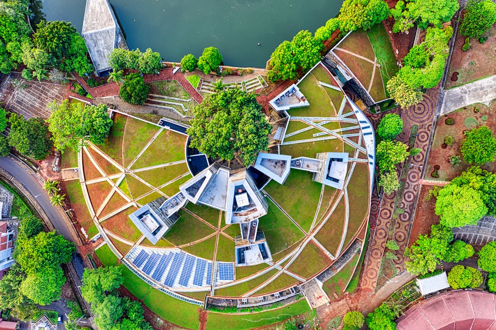 Drone shot of circular architectural design amidst lush greenery in Jawa Barat, Indonesia.
