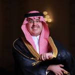 A smiling man in traditional Saudi clothing, embodying cultural elegance and celebration.